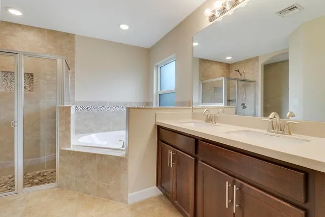 a bathroom with a double vanity sink mirror and shower