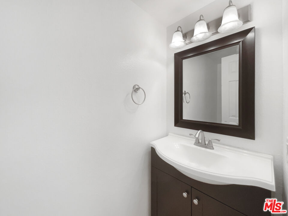 6864 Hatillo Avenue, Unit E Winnetka, CA 91306 - Photo 11 of 18 a bathroom with a sink vanity and mirror