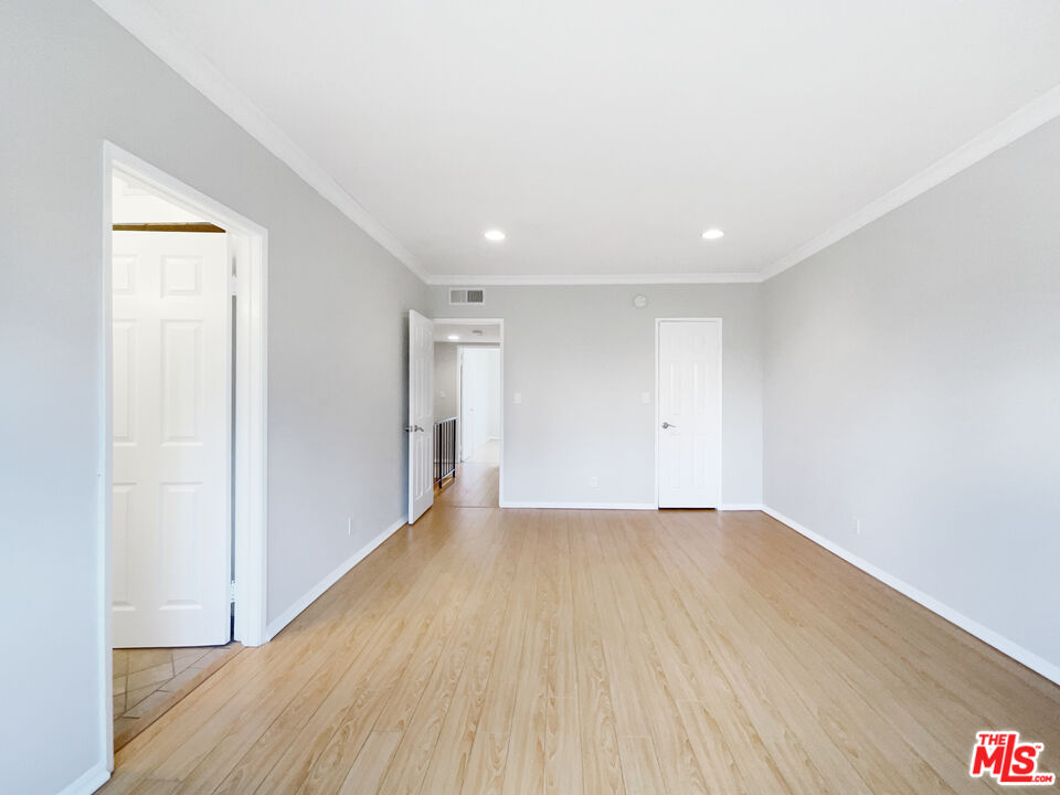6864 Hatillo Avenue, Unit E Winnetka, CA 91306 - Photo 12 of 18 a view of an empty room with wooden floor
