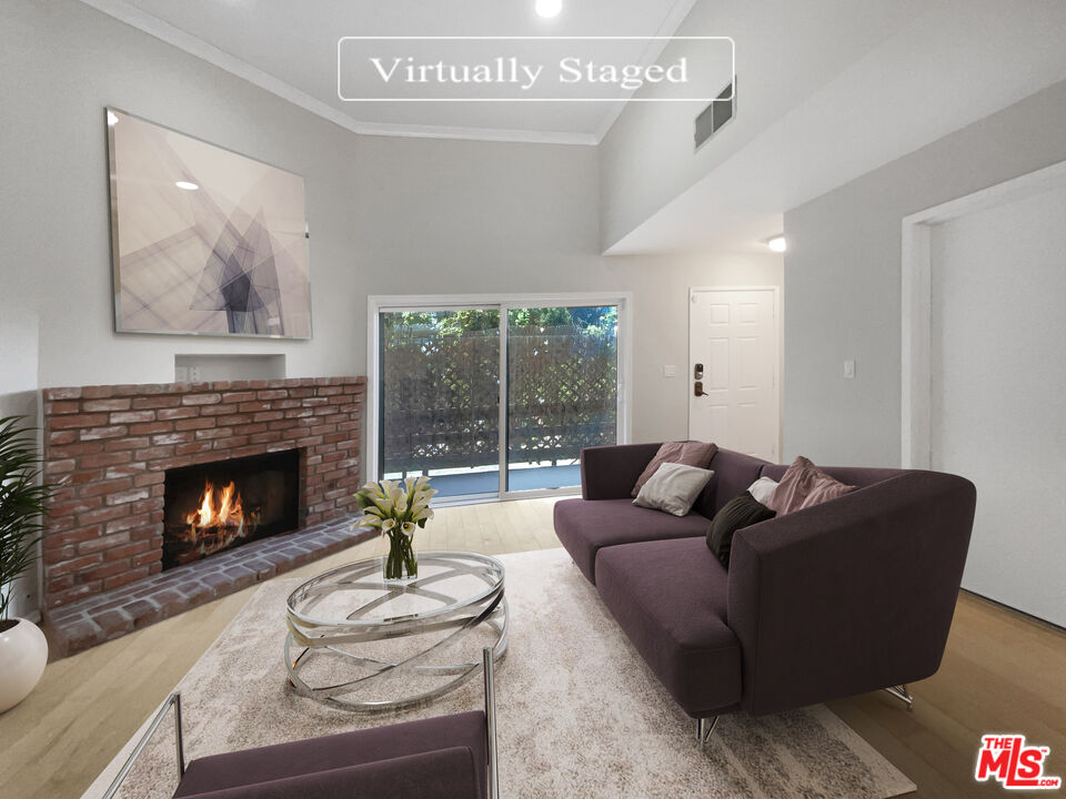 6864 Hatillo Avenue, Unit E Winnetka, CA 91306 - Photo 2 of 18 a living room with furniture a fireplace and a large window