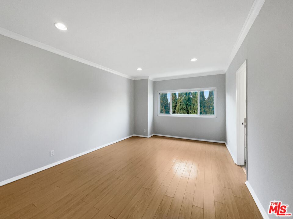 6864 Hatillo Avenue, Unit E Winnetka, CA 91306 - Photo 5 of 18 wooden floor in an empty room with a window