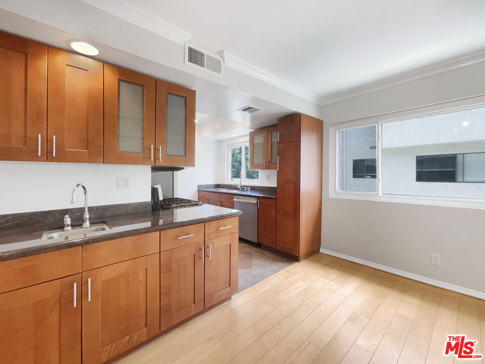 6864 Hatillo Avenue, Unit E Winnetka, CA 91306 - Photo 8 of 18 a kitchen with granite countertop stainless steel appliances a sink and cabinets