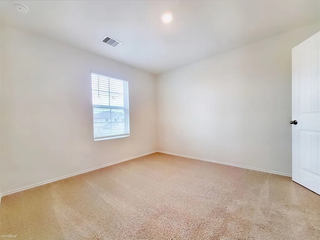 419 Sickle Loop Kyle, TX 78640 - Photo 23 of 35 A well-lit room with plush carpeting, offering a tranquil retreat.