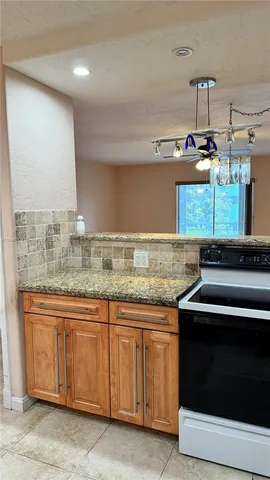 a kitchen with granite countertop a stove and a sink