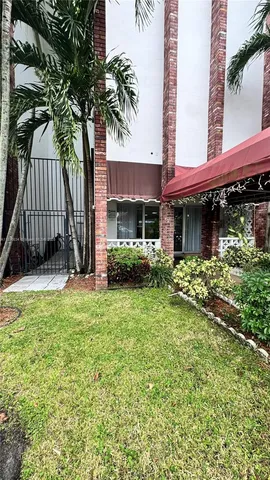 a view of a house with a yard and potted plants