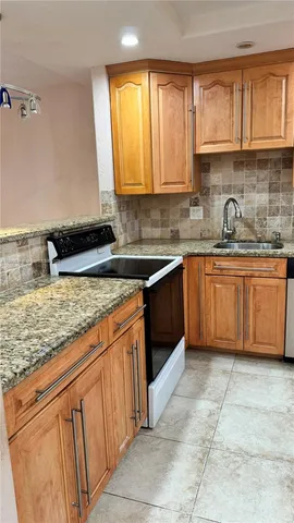 a kitchen with stainless steel appliances granite countertop a sink stove and cabinets