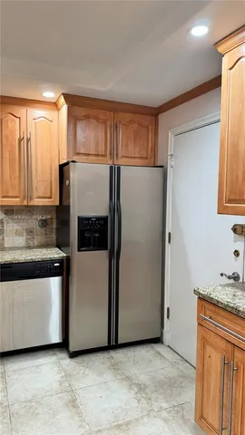 a refrigerator freezer sitting in a kitchen with stainless steel appliances granite countertop cabinets and a refrigerator