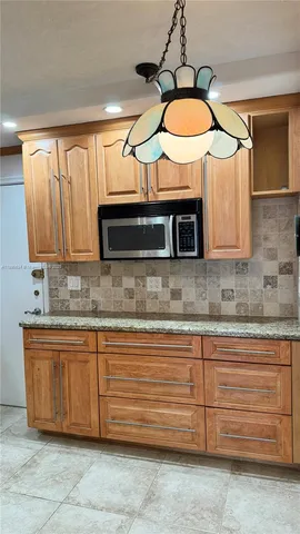 a kitchen with granite countertop a sink and a microwave