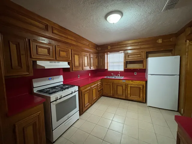 a kitchen with stainless steel appliances granite countertop a stove a sink and a refrigerator
