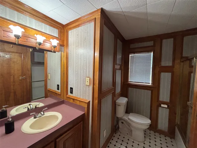 a bathroom with a sink toilet a mirror and shower