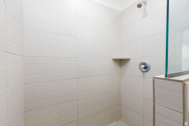 3157 Deseret Drive St. George, UT 84790 - Photo 12 of 24 Tiled shower enclosure featuring a fixed showerhead, built-in corner shelf, and chrome fixtures