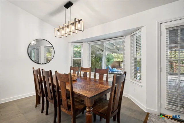 a dining room with furniture a rug and a window