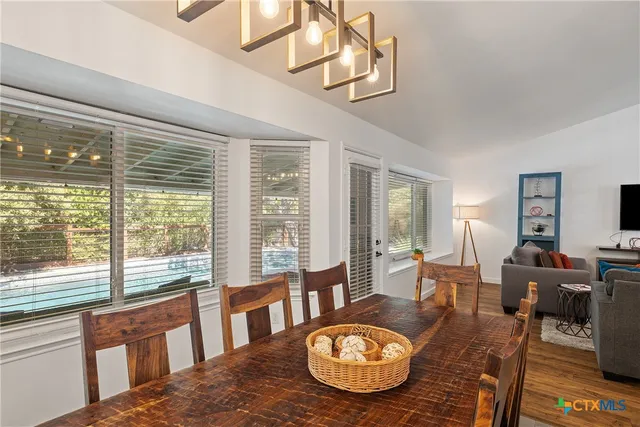 a view of a dining room with furniture wooden floor and chandelier