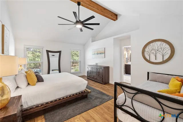 a bedroom with a bed a mirror on desk and chair