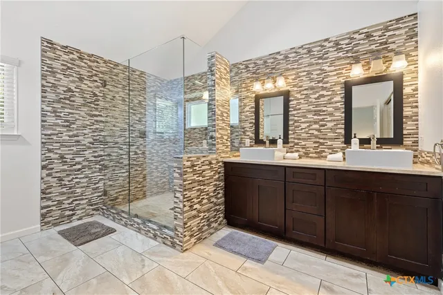 a bathroom with a sink a mirror and a shower