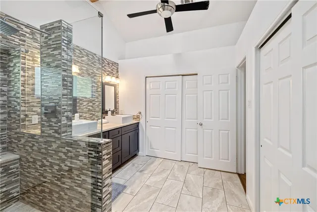 a bathroom with a granite countertop sink a toilet and shower