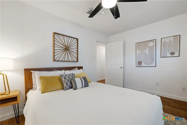 a bedroom with a bed and wooden floor