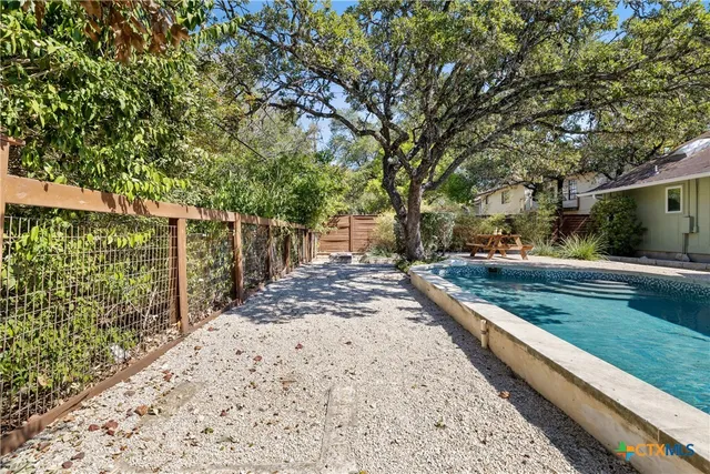 a view of a yard with wooden fence