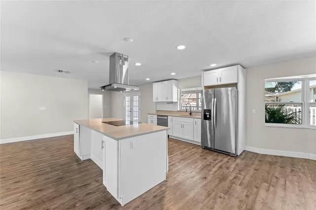 a kitchen with stainless steel appliances kitchen island granite countertop a stove and a refrigerator