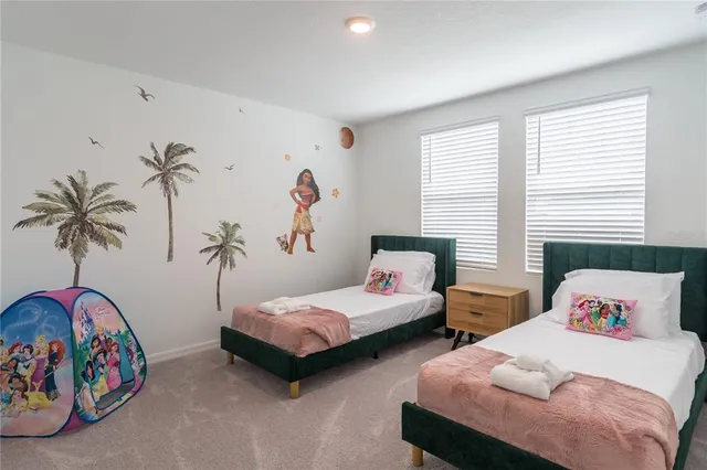 a bedroom with two beds and a potted plant