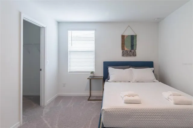 a large bed sitting in a bedroom next to a window