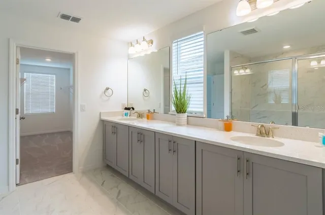 a bathroom with double vanity sinks and a mirror