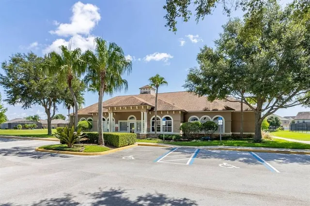 a view of a house with a yard and palm trees