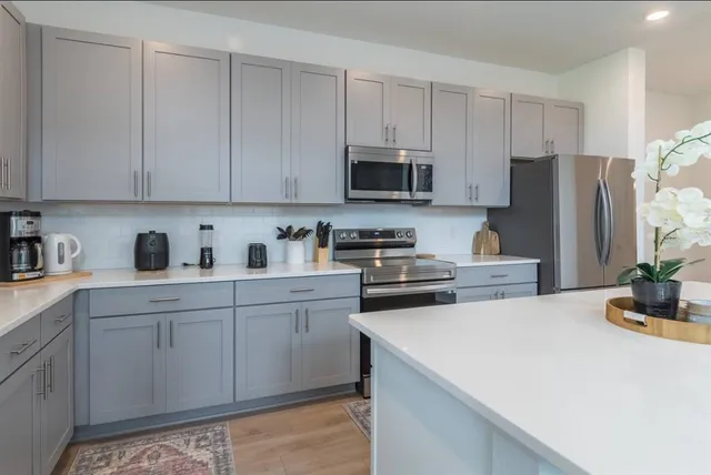 a kitchen with stainless steel appliances a stove a sink a refrigerator and cabinets