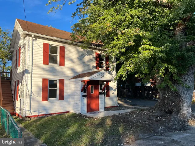 a view of a house with a yard and large tree