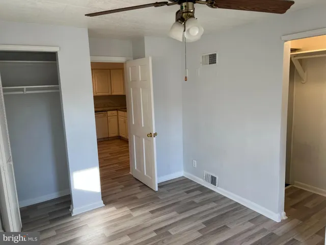 an empty room with a ceiling fan and a window