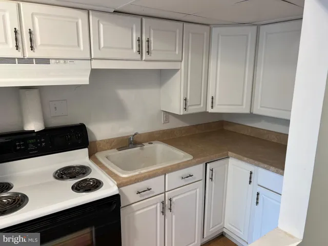 a kitchen with granite countertop a sink and a stove