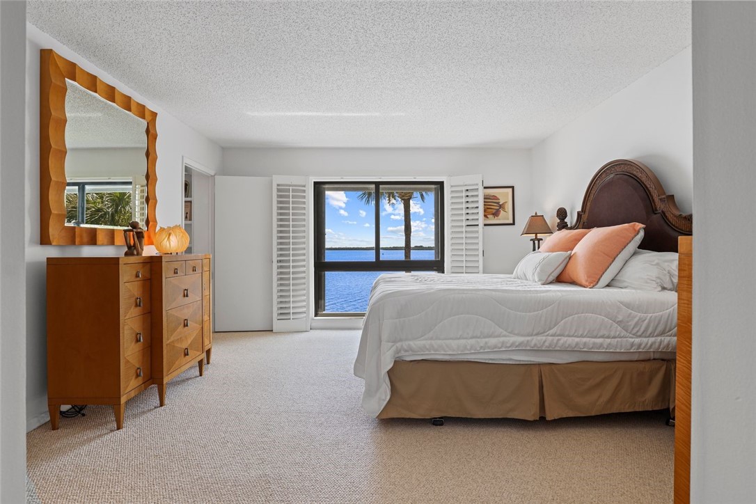 1001 Bay Road, Unit 302 Vero Beach, FL 32963 - Photo 14 of 31 a bedroom with a bed and a dresser next to a window