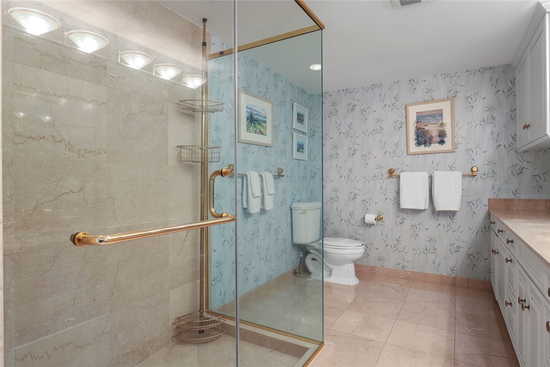 1001 Bay Road, Unit 302 Vero Beach, FL 32963 - Photo 17 of 31 a bathroom with a granite countertop shower a toilet and sink