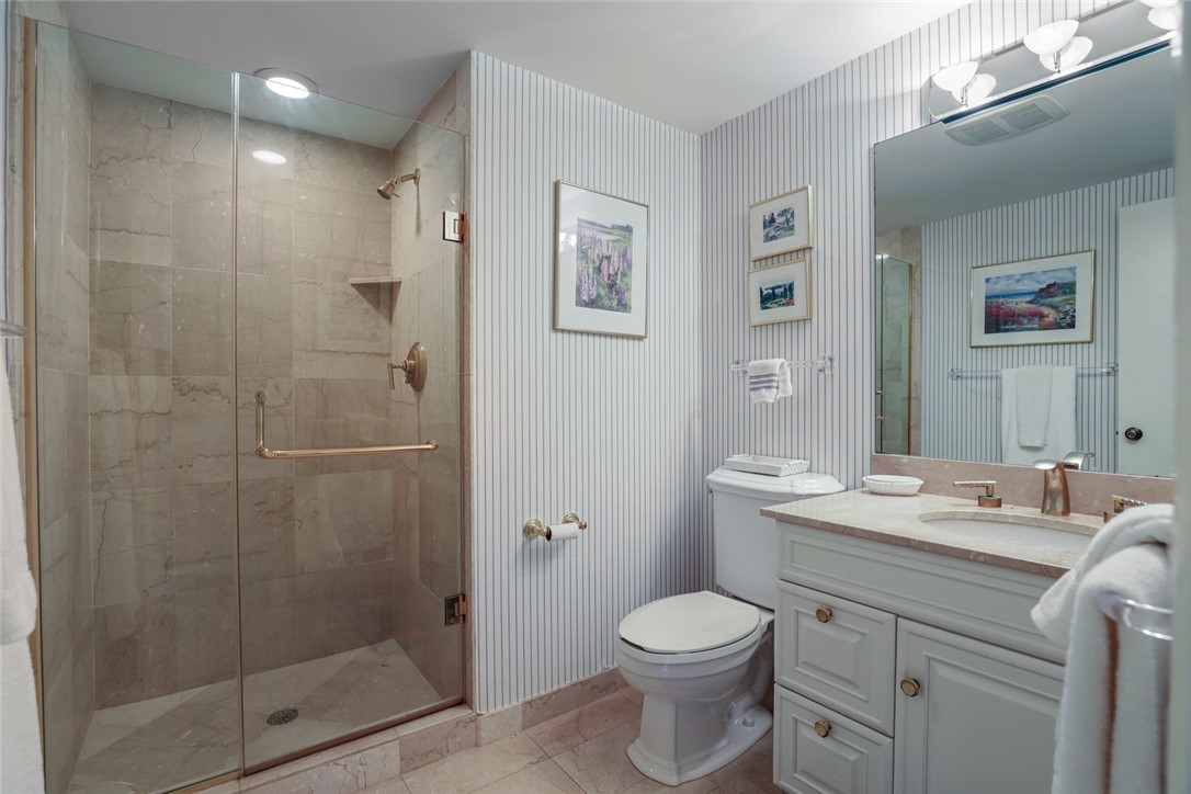 1001 Bay Road, Unit 302 Vero Beach, FL 32963 - Photo 20 of 31 a bathroom with a sink toilet and shower