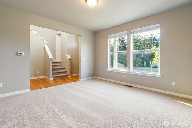a view of an empty room with a fireplace and a window