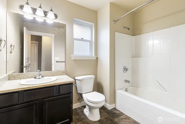 a bathroom with a sink a toilet a mirror and bathtub