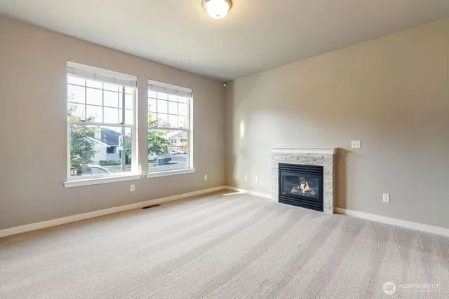 an empty room with fireplace and windows