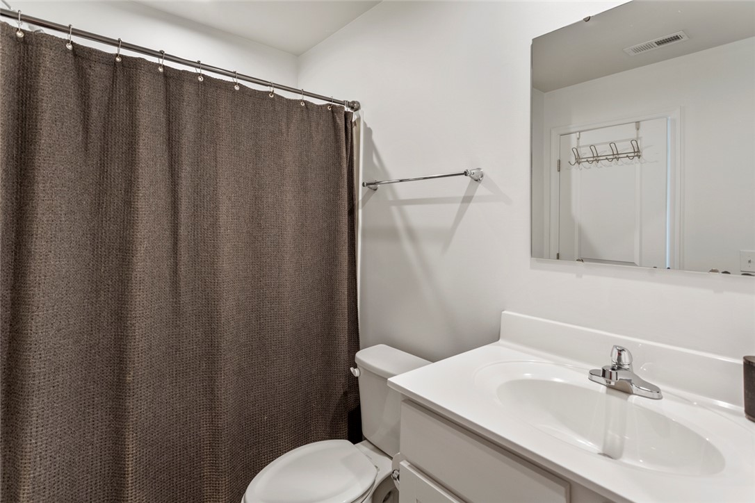 137 Nicklaus Drive Anderson, SC 29621 - Photo 25 of 37 A well-appointed bath features a sleek white vanity and a practical shower with a deep brown curtain.
