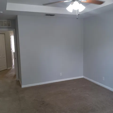 a view of a small space with a chandelier fan