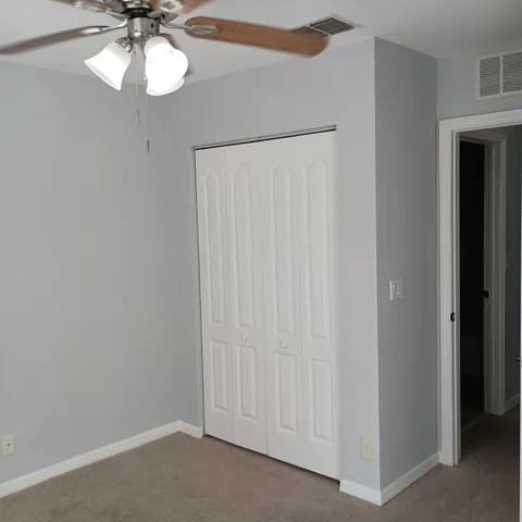 a view of a chandelier fan and closet area
