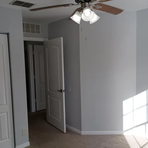 a view of a chandelier fan and entryway
