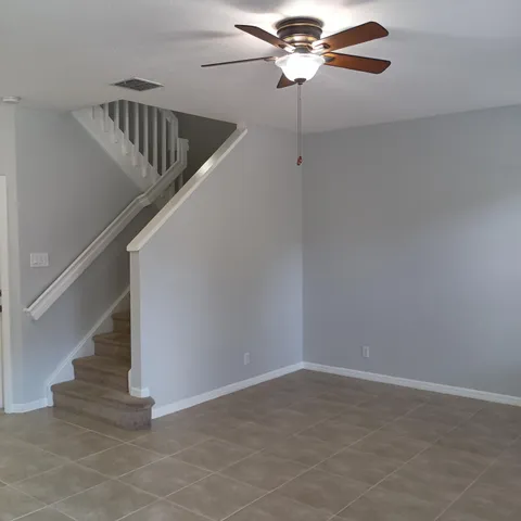 a view of staircase with wooden floor and fan
