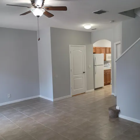 an empty room with chandelier fan and closet
