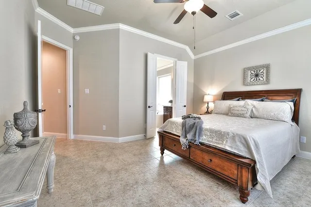 a spacious bedroom with a bed and a chandelier