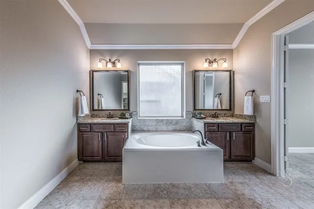 a spacious bathroom with a tub sink and mirror