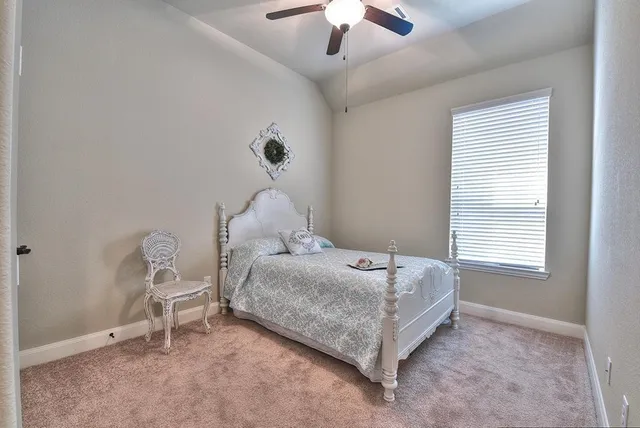 a bedroom with a bed chair and window
