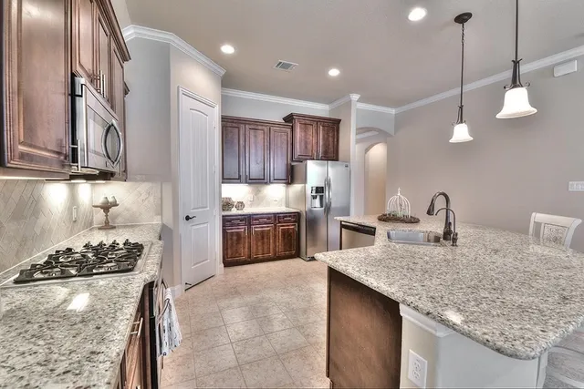 a kitchen with stainless steel appliances granite countertop a sink stove and refrigerator