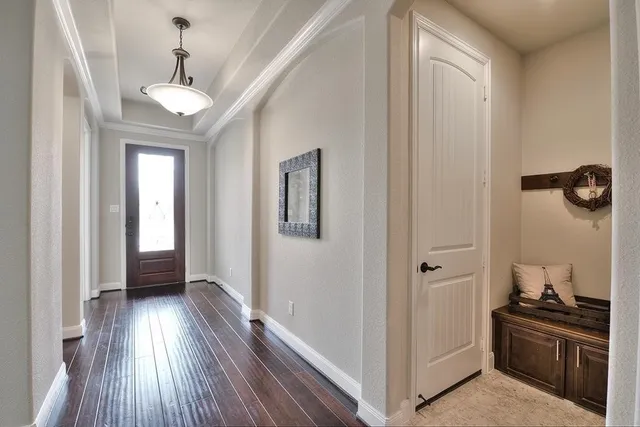 a view of hallway with a large mirror and wooden floor