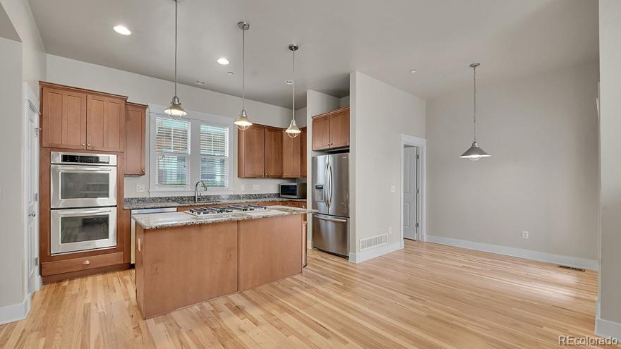 11718 Perry Street Westminster, CO 80031 - Photo 4 of 15 a kitchen with stainless steel appliances granite countertop a stove and a refrigerator