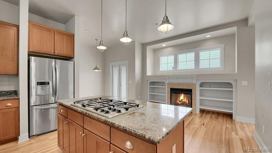 11718 Perry Street Westminster, CO 80031 - Photo 5 of 15 a kitchen with kitchen island granite countertop a stove and a refrigerator